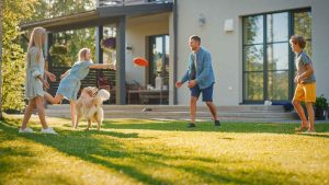 Family frisbee on lawn with dog